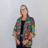Person wearing a colorful jacket with a plain background