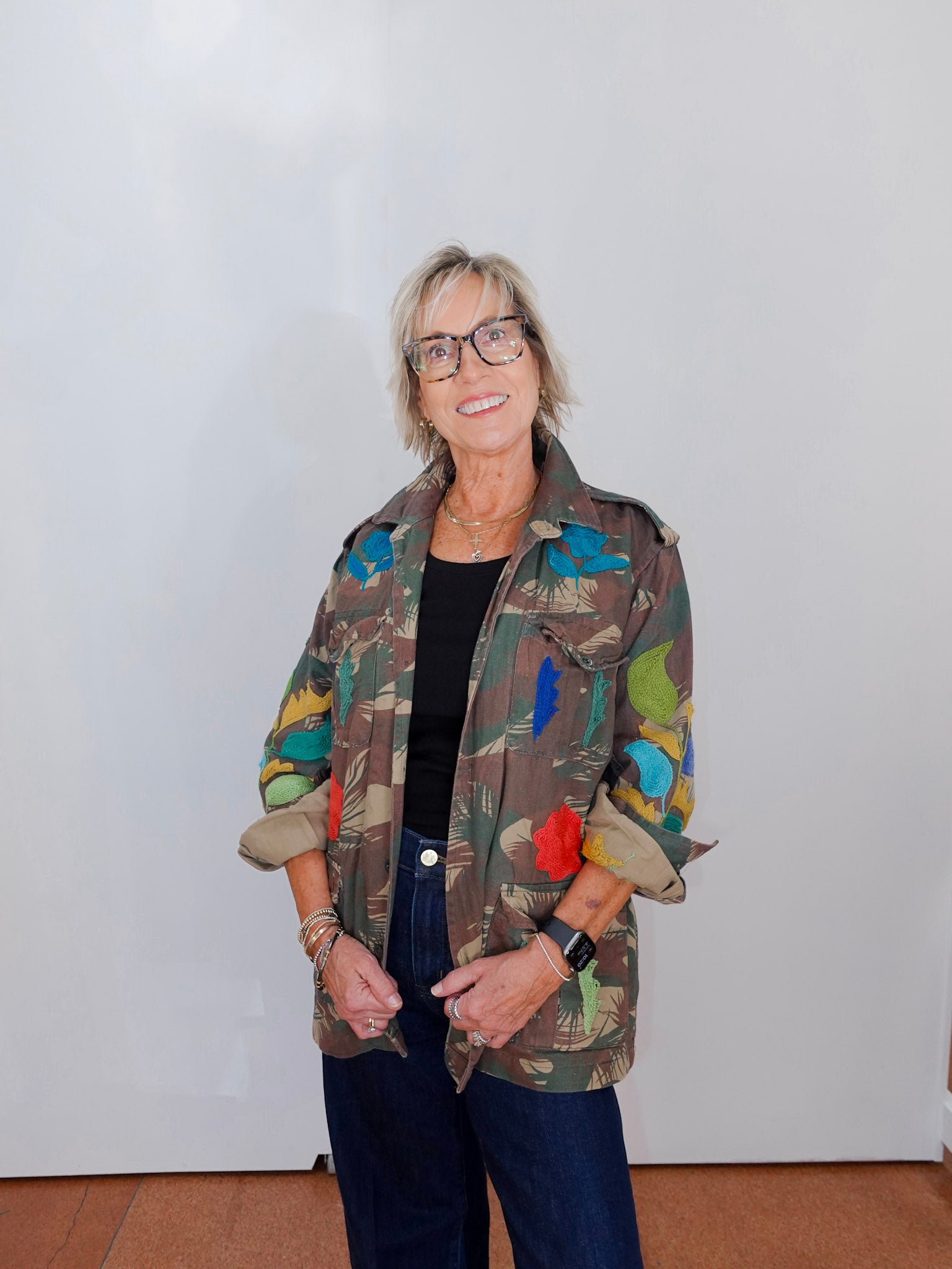 Person wearing a colorful jacket with a plain background