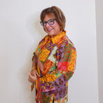 Woman wearing a colorful patchwork jacket against a white background