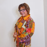Woman wearing a colorful patchwork jacket against a white background