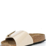 Beige sandal with a gold buckle on a white background