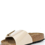 Beige sandal with a gold buckle on a white background