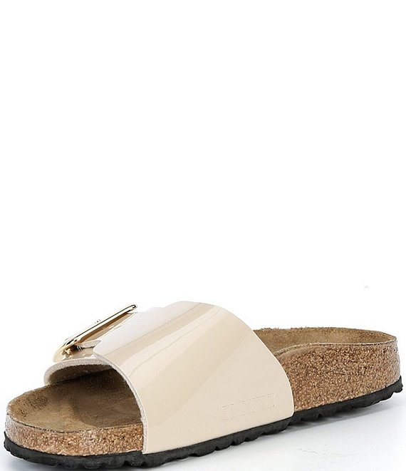 Beige sandal with a gold buckle on a white background