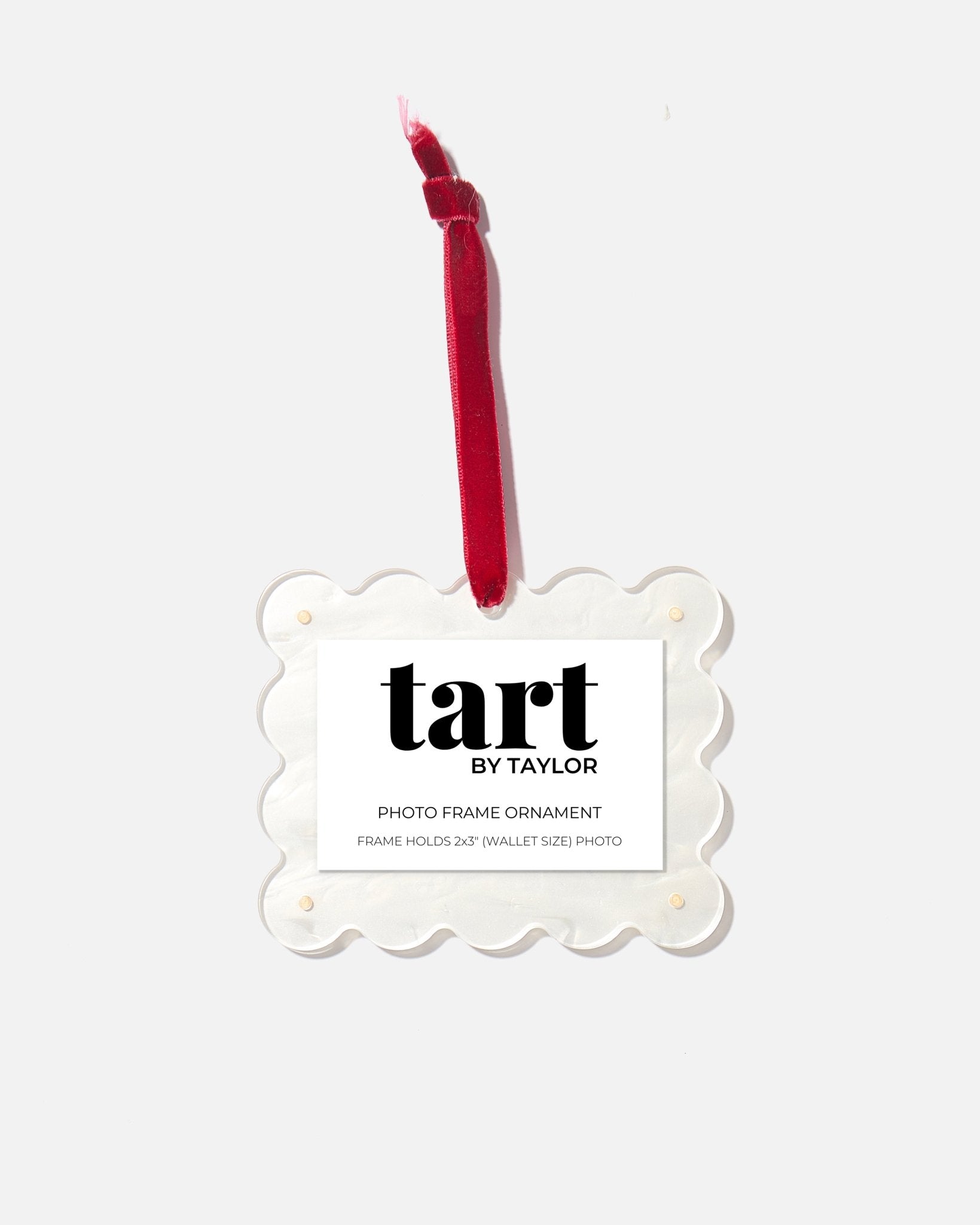 Decorative photo frame ornament with red candle on a white background, branded 'tart by Taylor'.