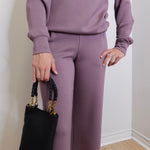 woman wearing the Black handbag with gold accents on a white background.