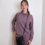 woman wearing the Black handbag with gold accents on a white background.