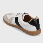 Sneaker with white, black, and brown color scheme on a light gray background