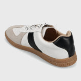 Sneaker with white, black, and brown color scheme on a light gray background