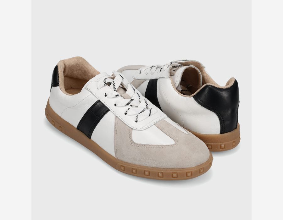 Pair of white and beige sneakers with black accents on a light gray background