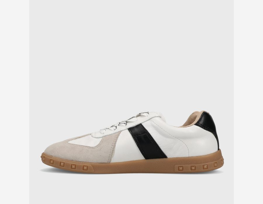 White sneaker with black accent and brown sole on a light gray background
