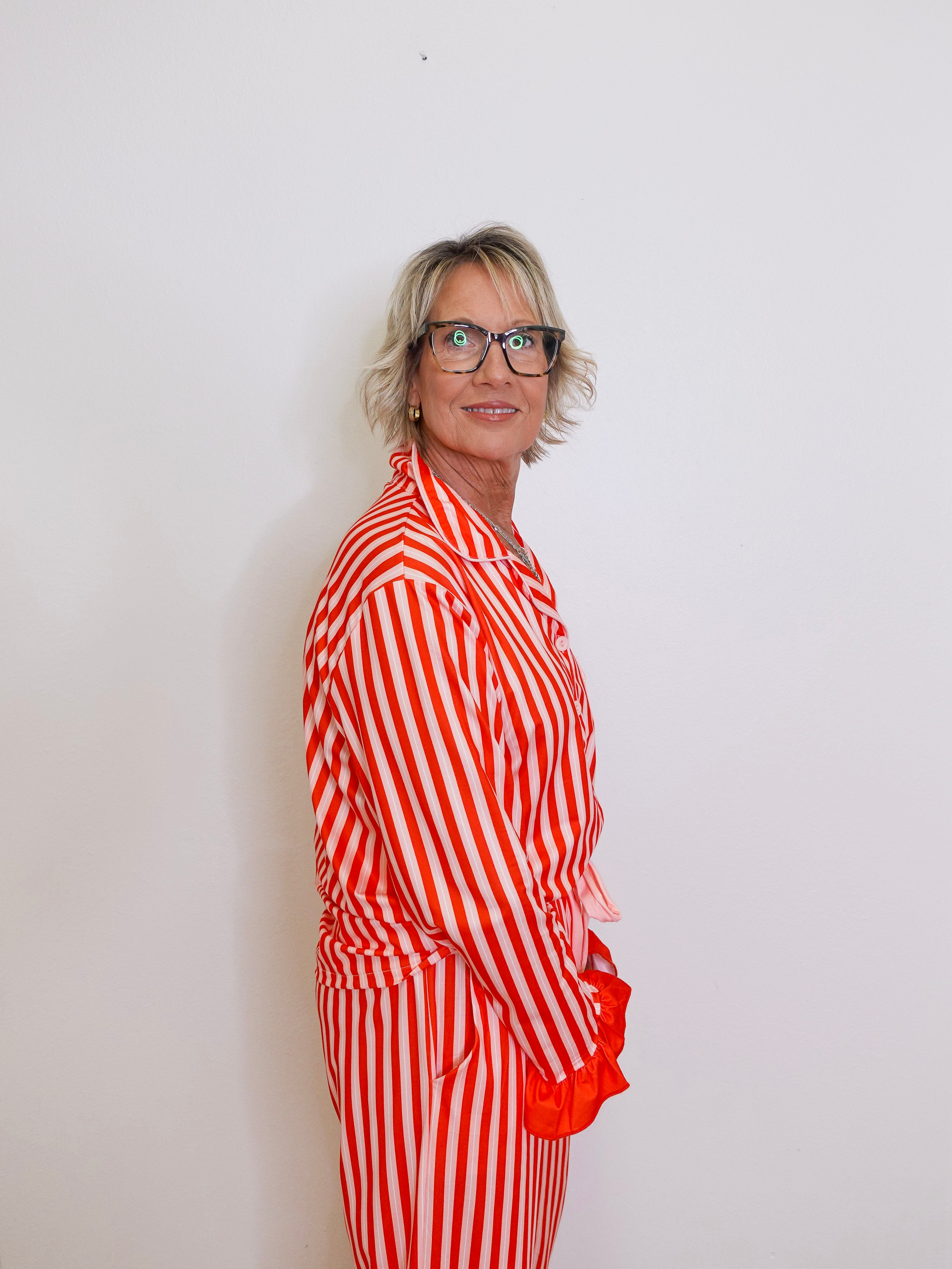 Person wearing a red and white striped outfit against a plain background