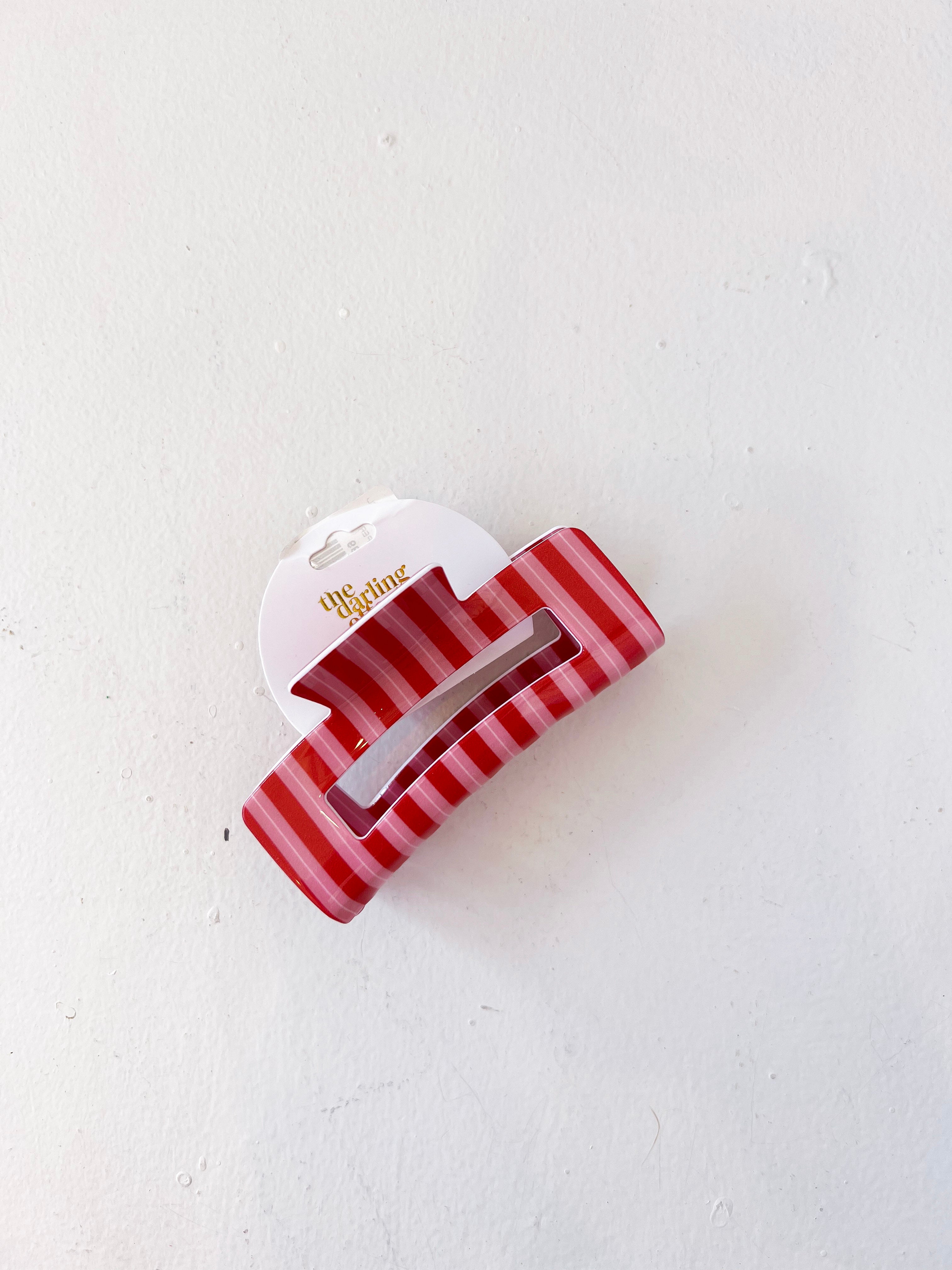 Red and white striped hair clip on a light gray background