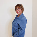 Woman wearing a blue denim jacket against a plain background