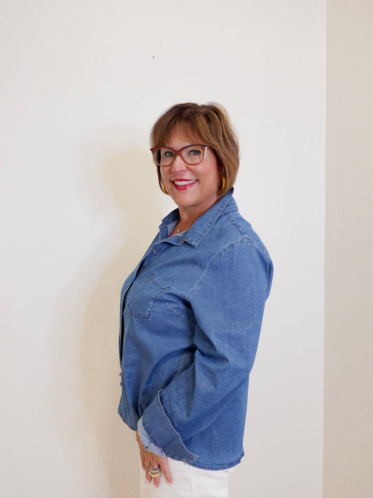 Woman wearing a blue denim jacket against a plain background