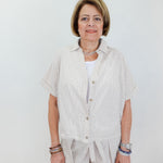 Woman wearing a light-colored outfit with a white background