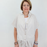 Woman wearing a light-colored outfit with a white background