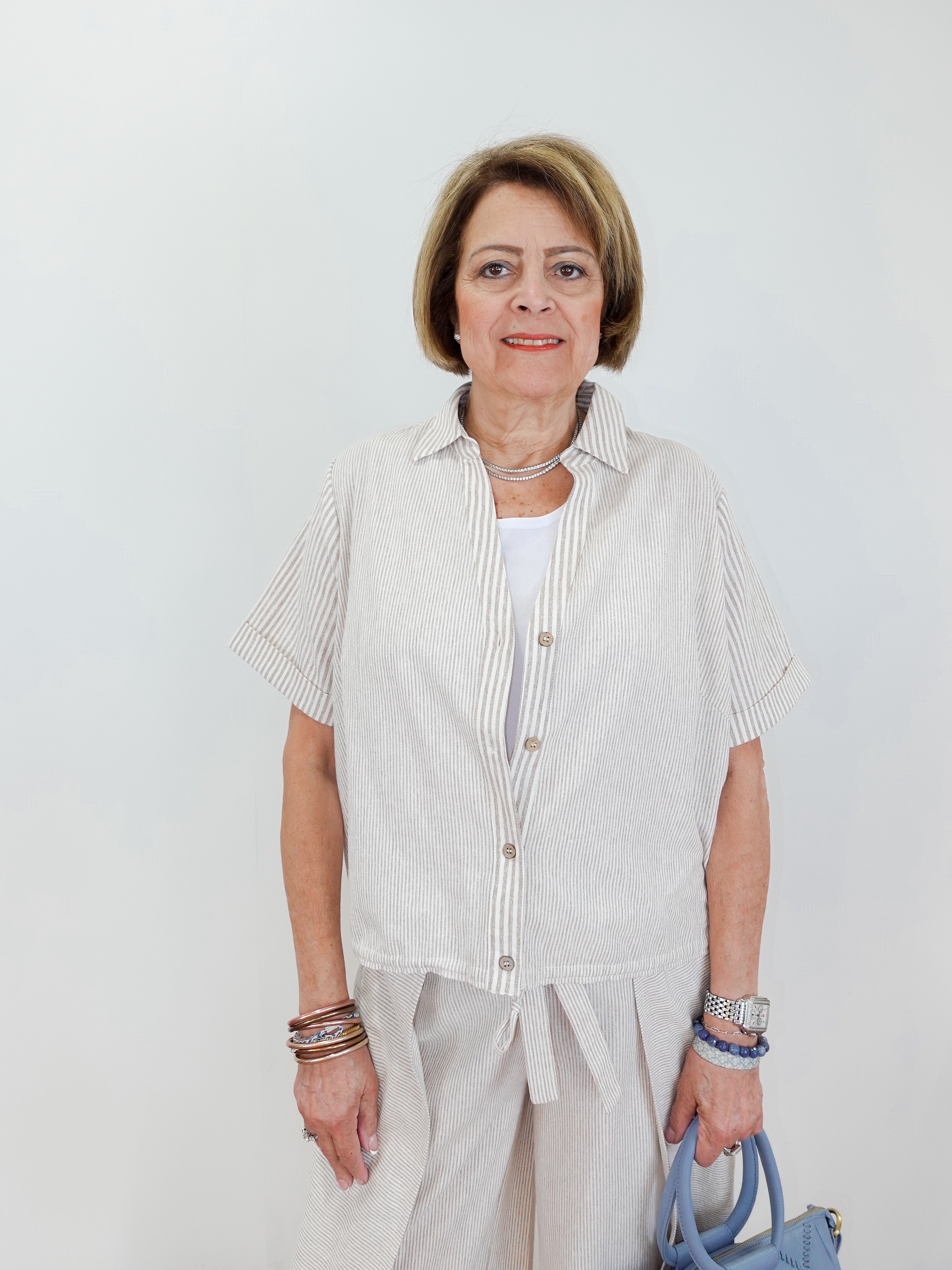 Woman wearing a light-colored outfit with a white background