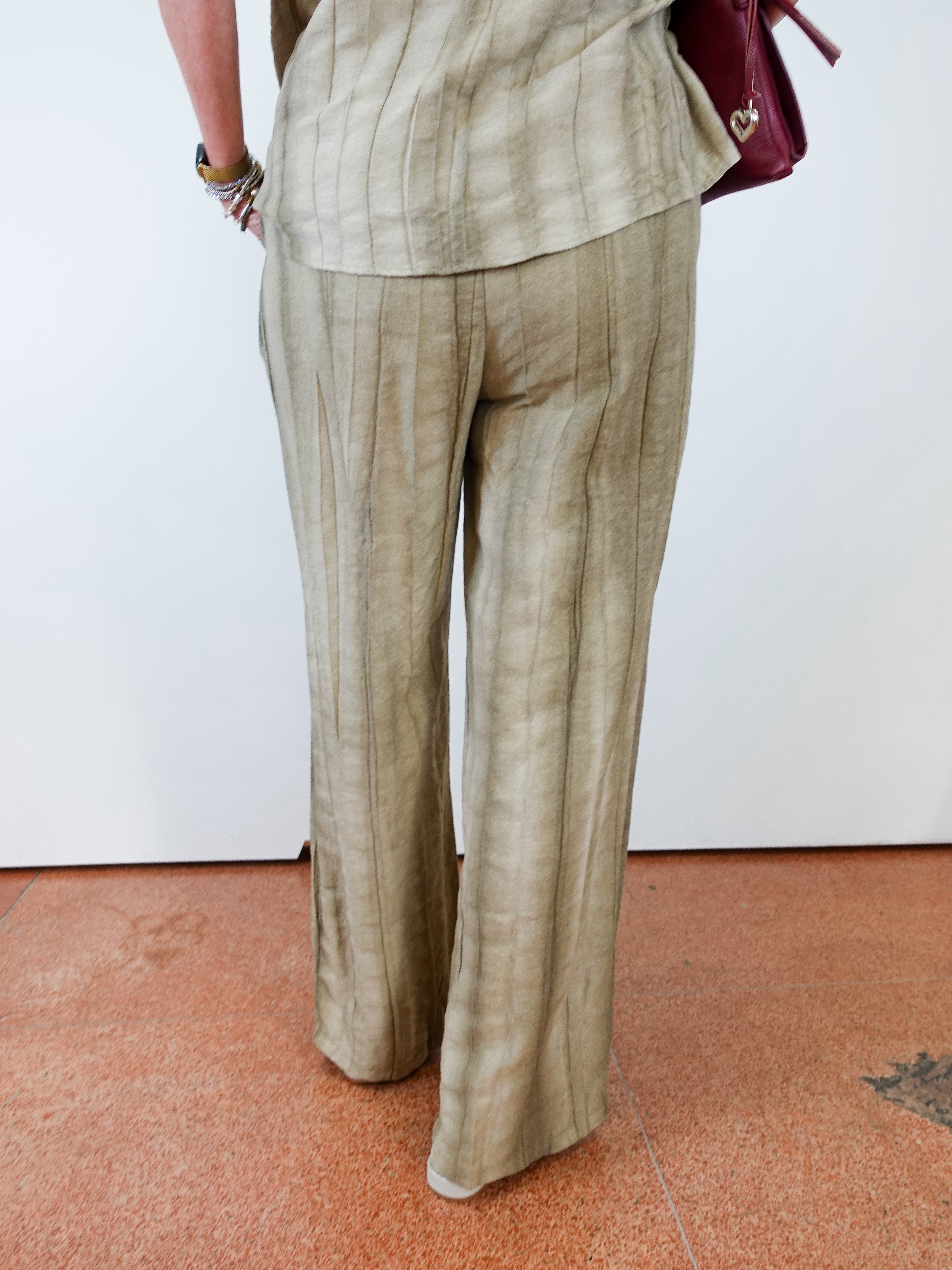 Person wearing a beige suit with a white wall background