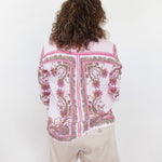 Person wearing a patterned shirt and shorts on a white background