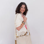 Woman holding a beige handbag against a white background