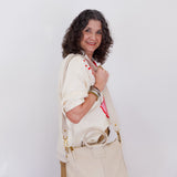 Woman holding a beige handbag against a white background