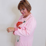 woman wearing a pink Santa baby long sleeve baby sweatshirt against a white background. 