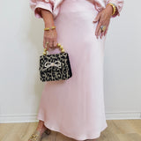woman wearing a pink satin skirt against a white background. 