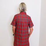 woman wearing a plaid short sleeve dress against a white background