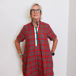 woman wearing a plaid short sleeve dress against a white background