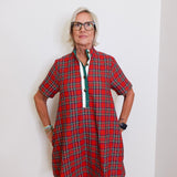 woman wearing a plaid short sleeve dress against a white background