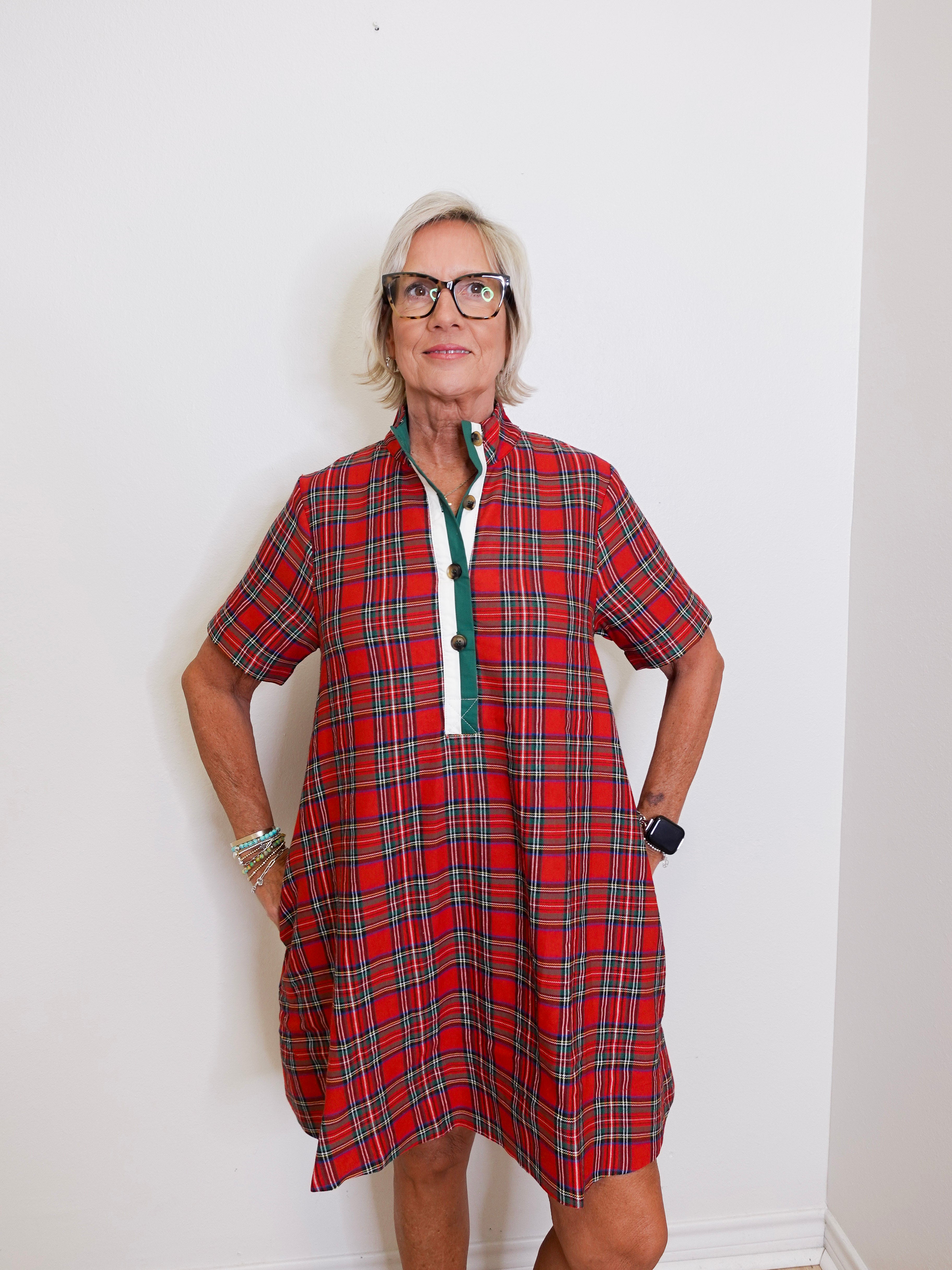 woman wearing a plaid short sleeve dress against a white background