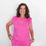 Woman wearing a bright pink outfit against a white background