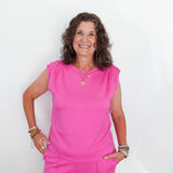 Woman wearing a bright pink outfit against a white background