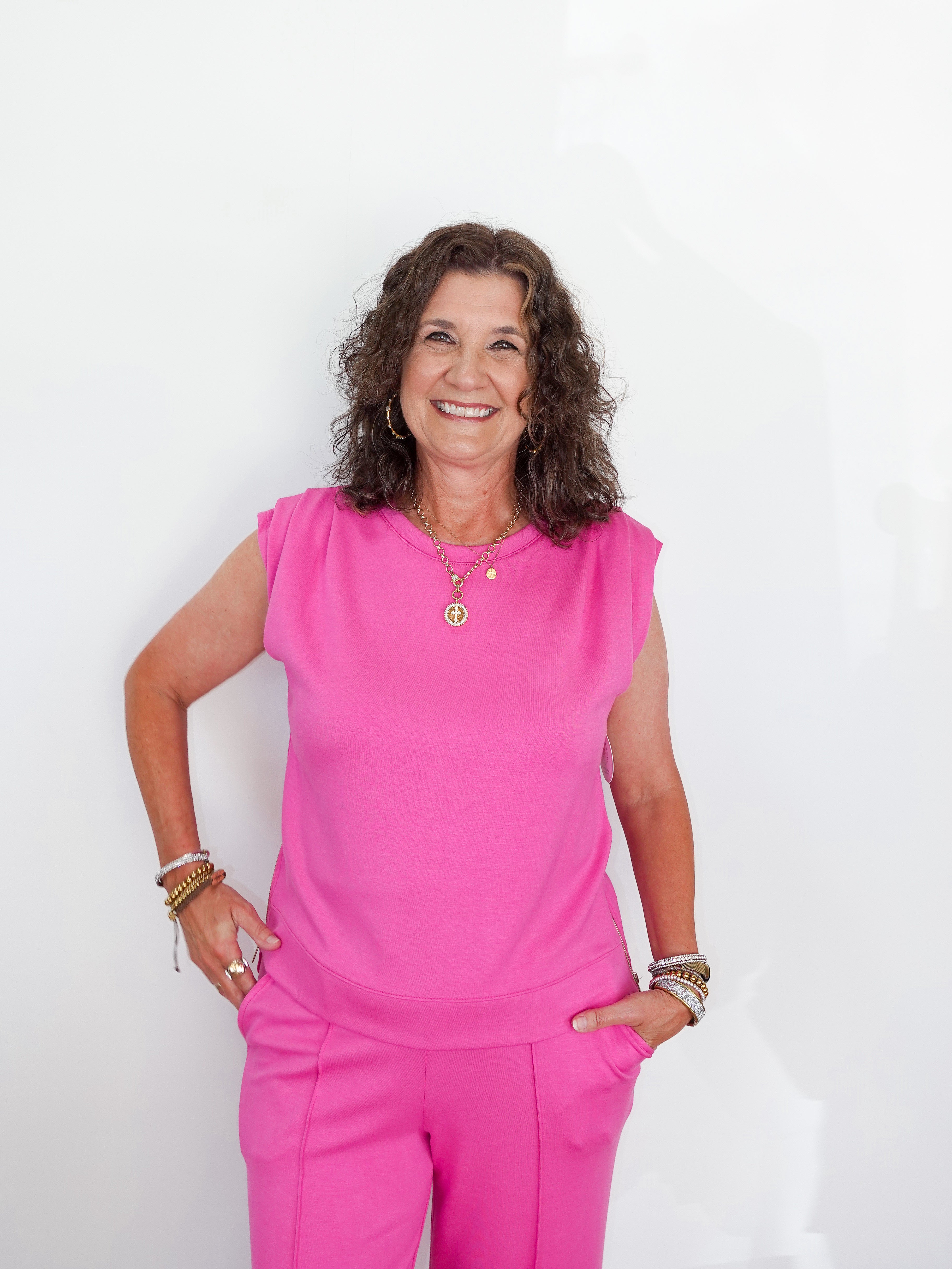 Woman wearing a bright pink outfit against a white background