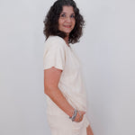 Woman wearing a white dress against a plain background