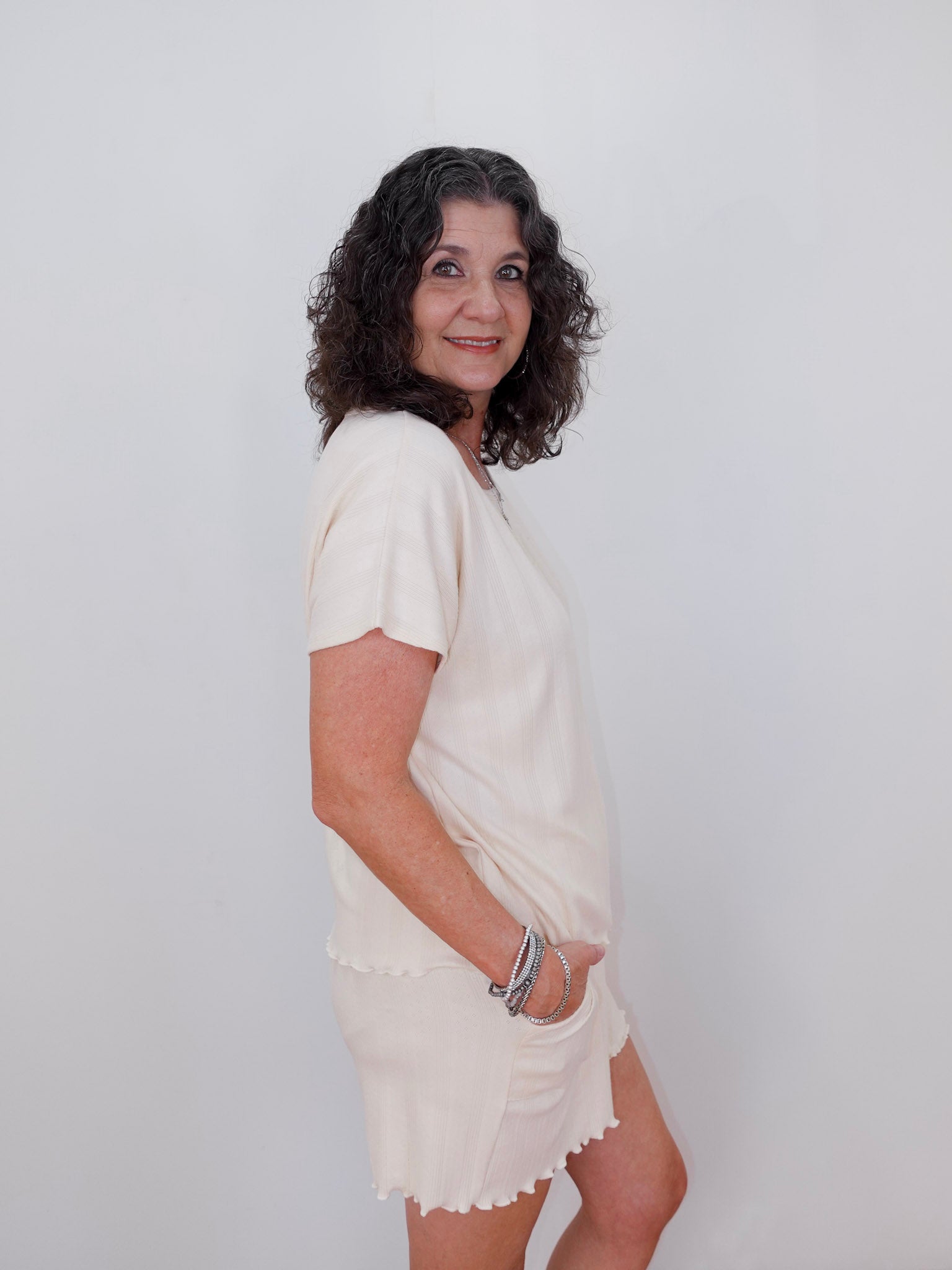 Woman wearing a white dress against a plain background