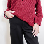 Woman wearing a black pant against a white background. 