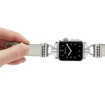 Smartwatch with decorative band held by a hand on a white background