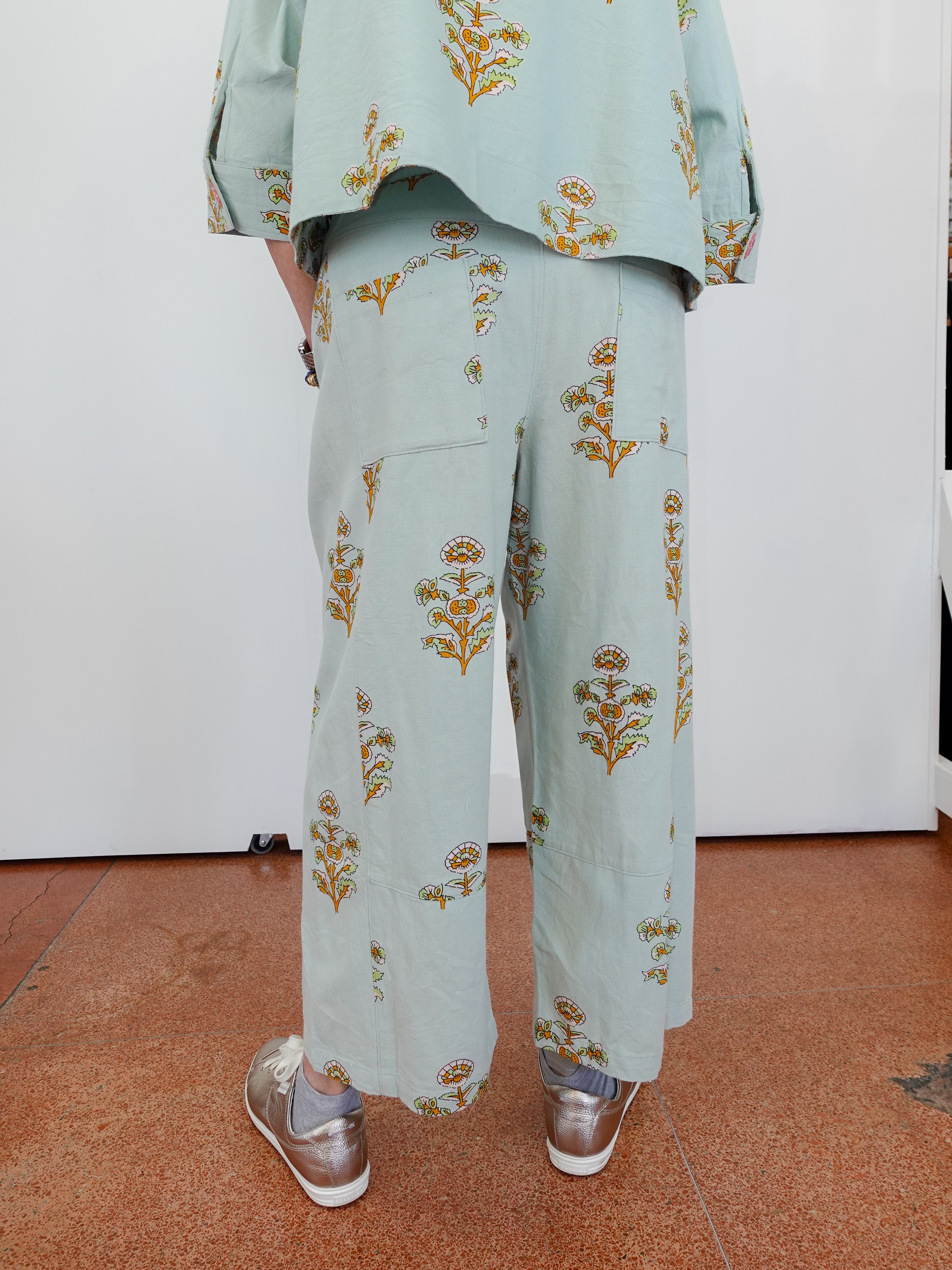 Person wearing a light blue floral outfit on a white background