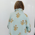 Light blue floral patterned jacket worn by a person on a white background