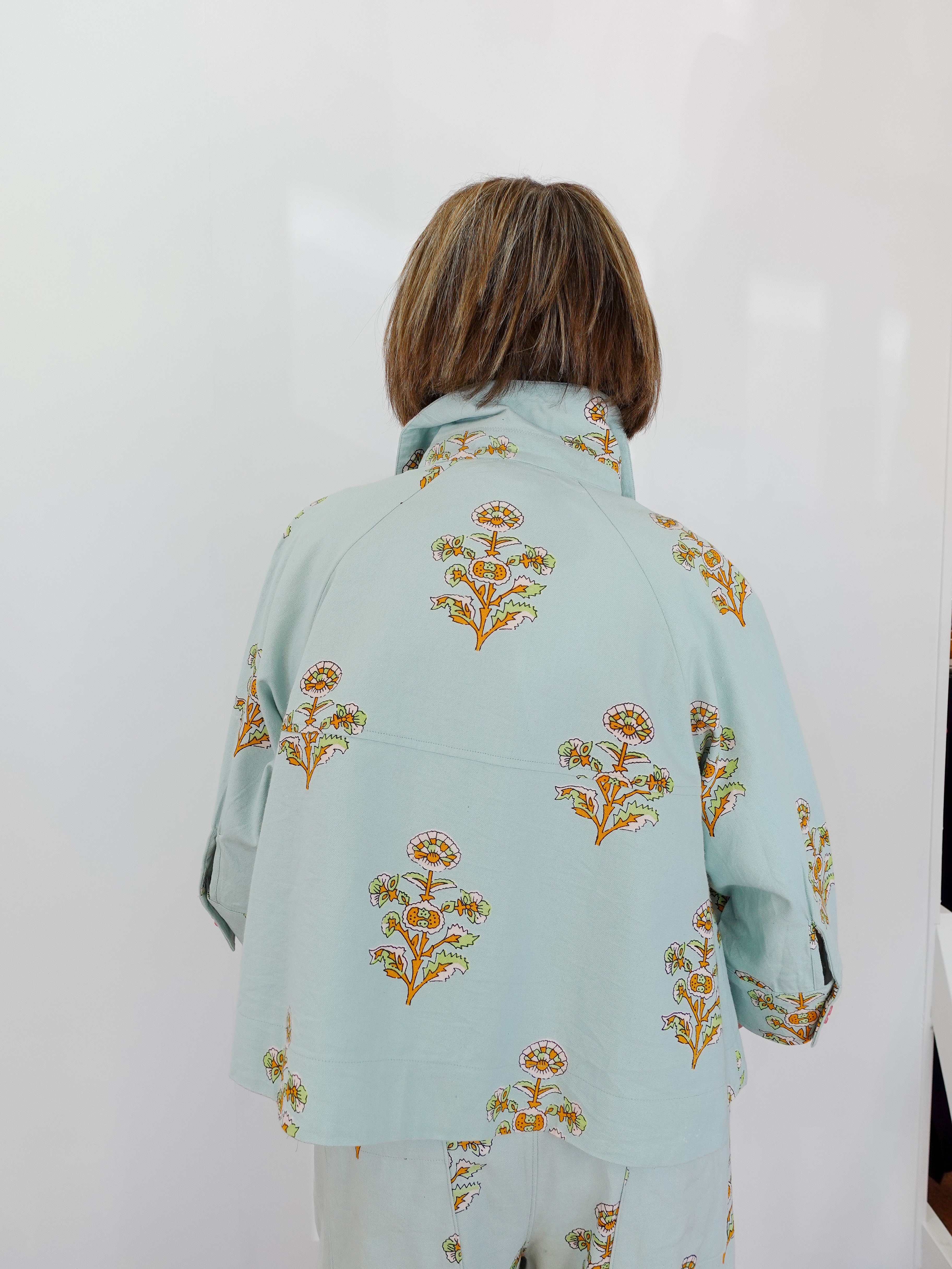 Light blue floral patterned jacket worn by a person on a white background