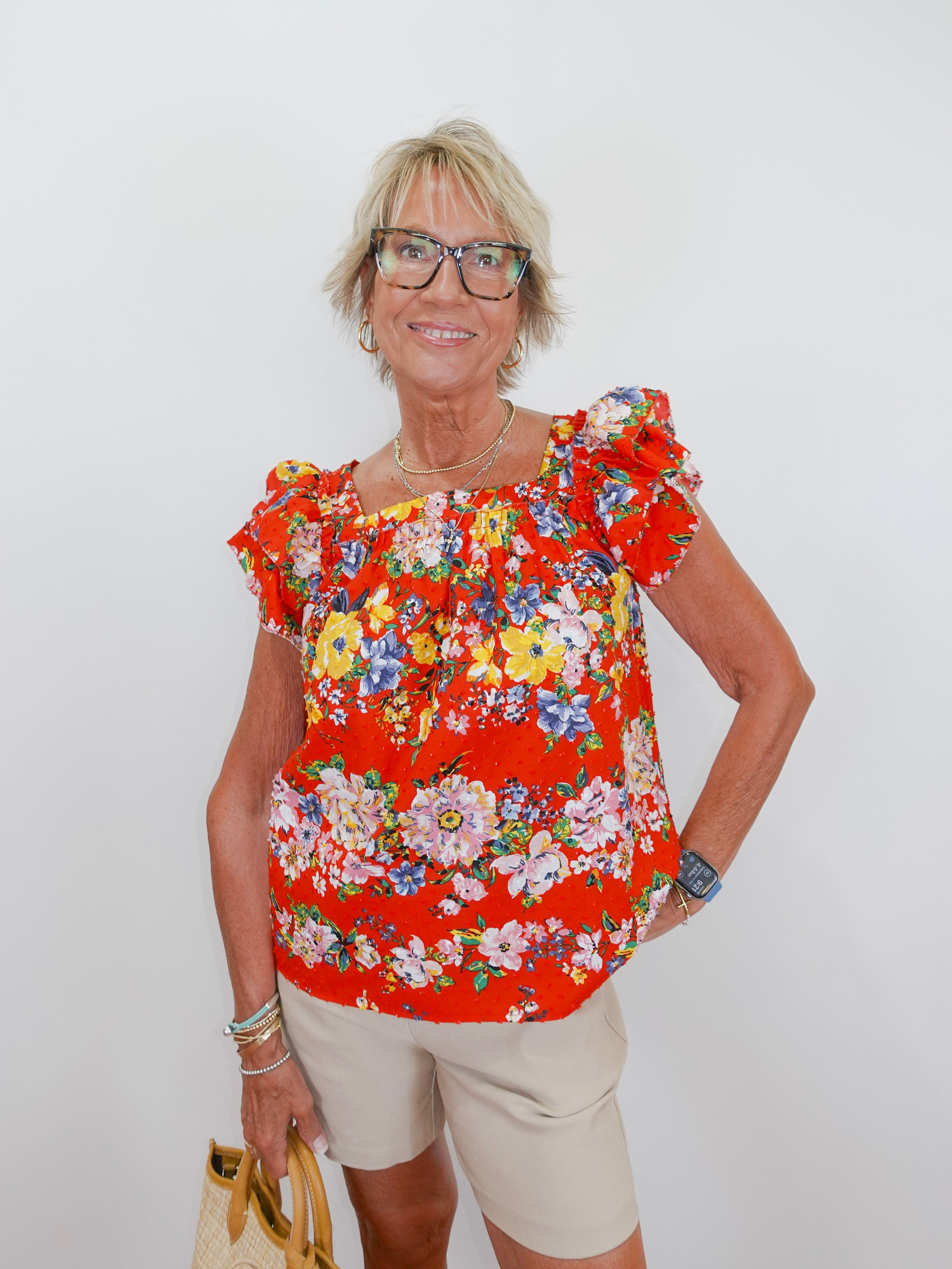 Woman wearing a red floral blouse against a white background