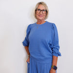 Woman wearing a blue outfit against a white background