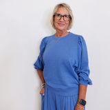 Woman wearing a blue outfit against a white background