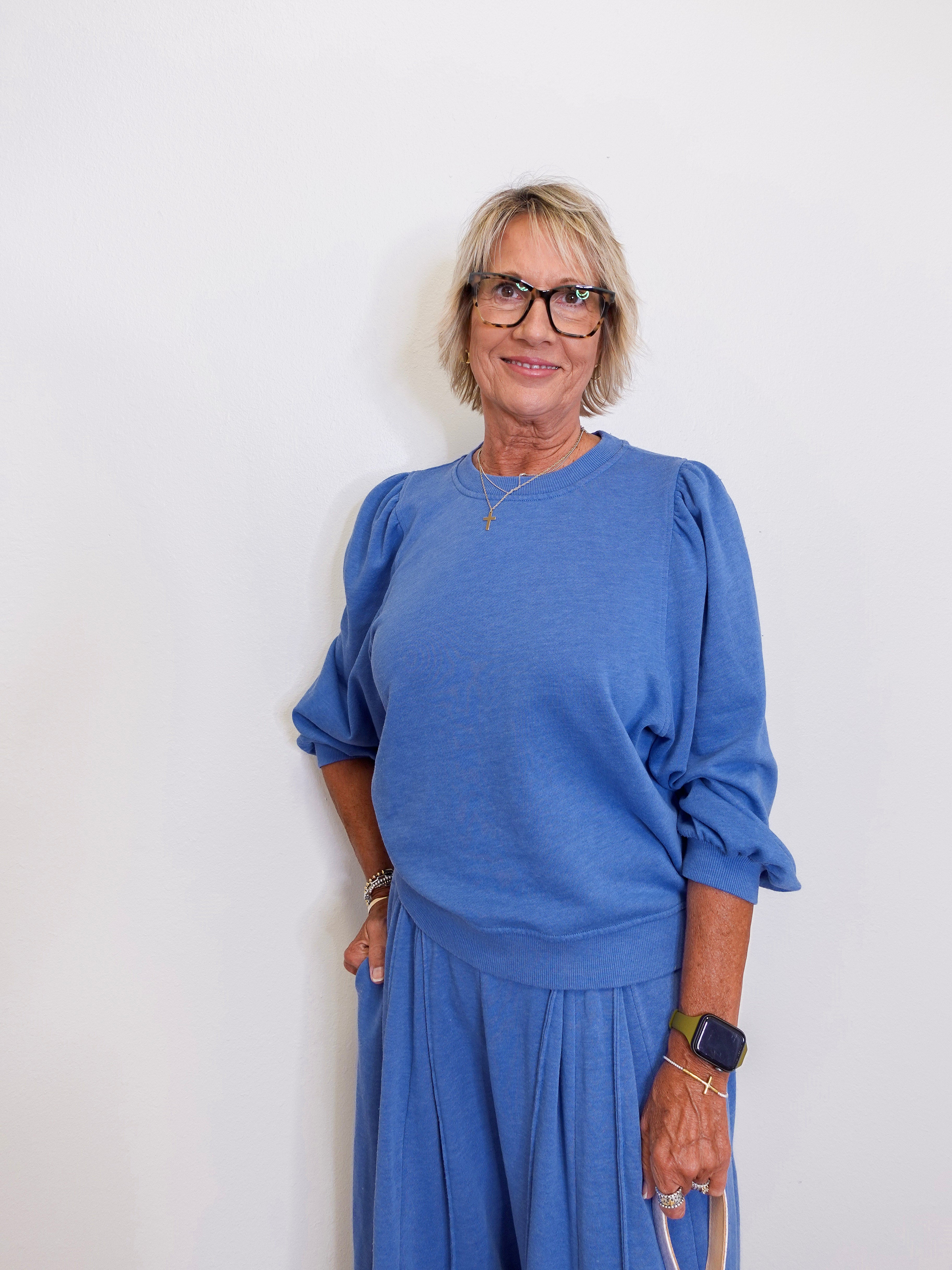 Woman wearing a blue outfit against a white background