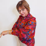 Woman wearing a puff sleeve blouse against a white background. 