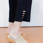 Person wearing transparent sandals with wooden soles on a light-colored floor.