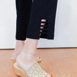 Person wearing transparent sandals with wooden soles on a light-colored floor.