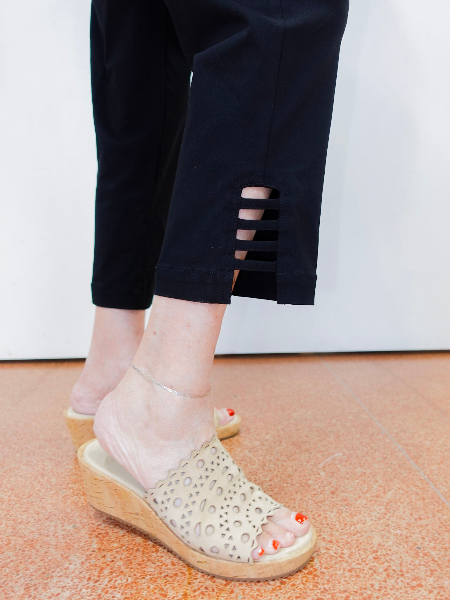 Person wearing transparent sandals with wooden soles on a light-colored floor.