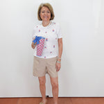 Woman holding a colorful bag against a white wall